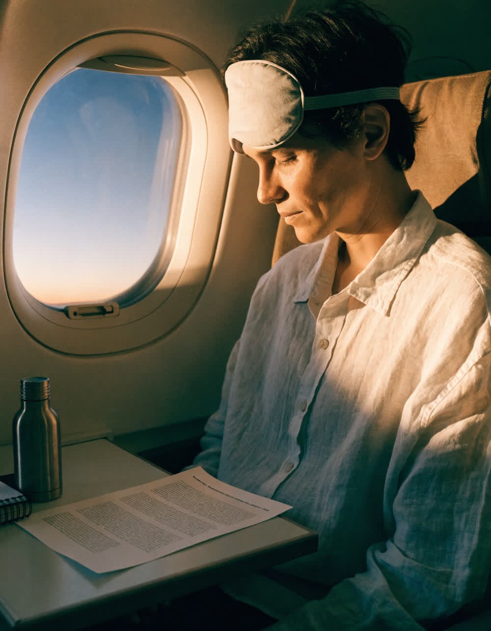 A calm traveller in a window seat consulting a printed reference sheet.