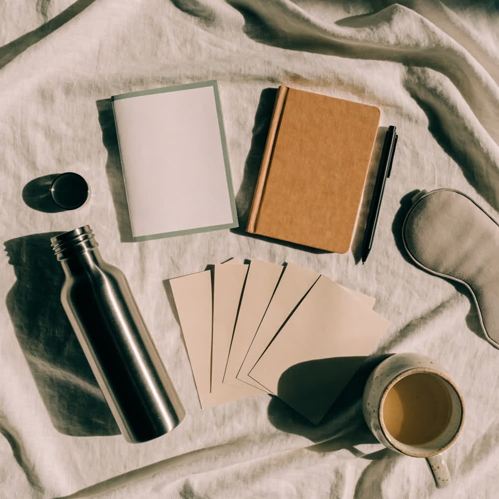 The Travel Well Kit laid out: printed booklet, folded reference sheets, notebook, water bottle and eye mask.